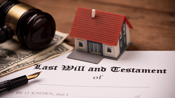 Last will and testament document with a fountain pen, gavel and model house